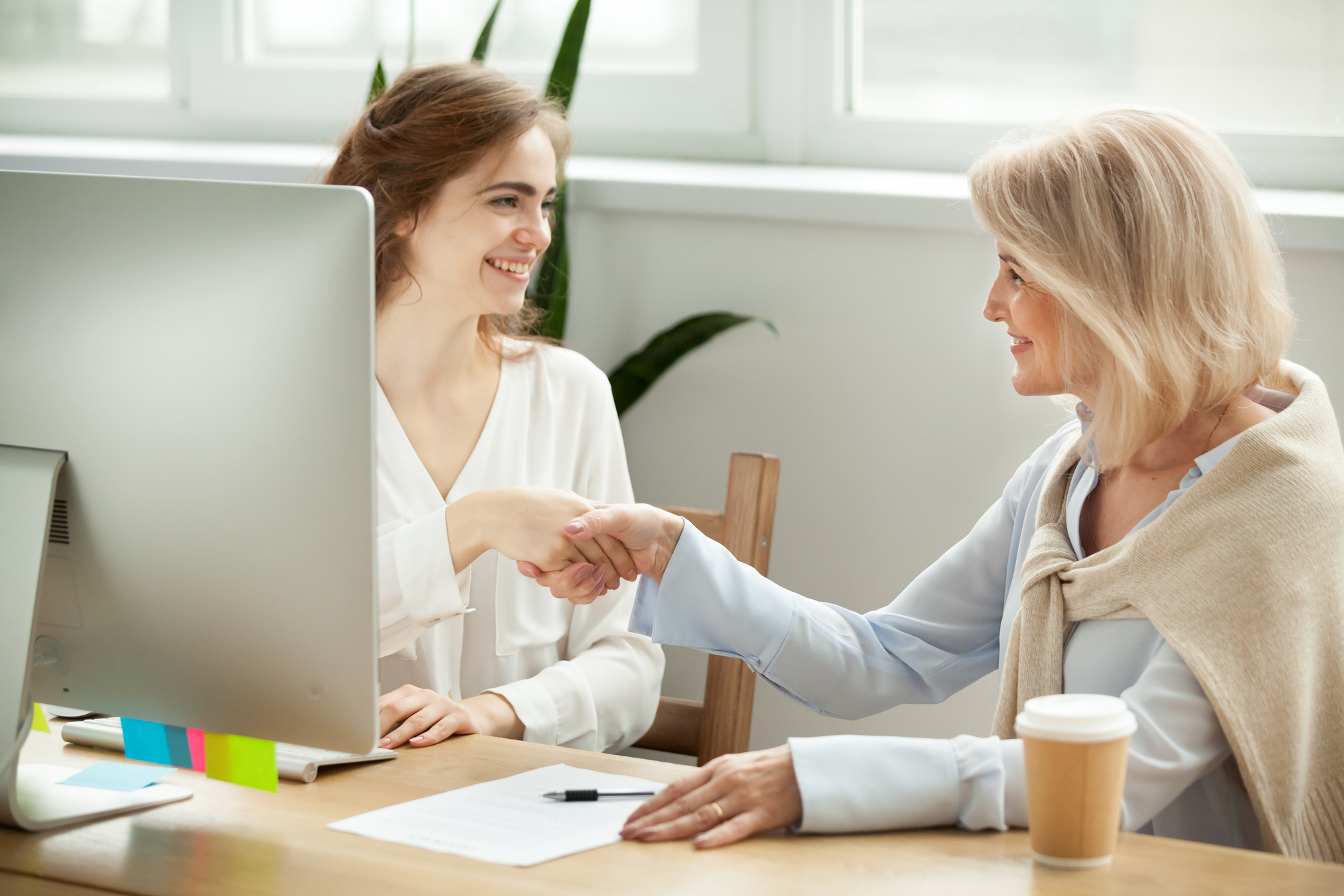 Two women shake hands